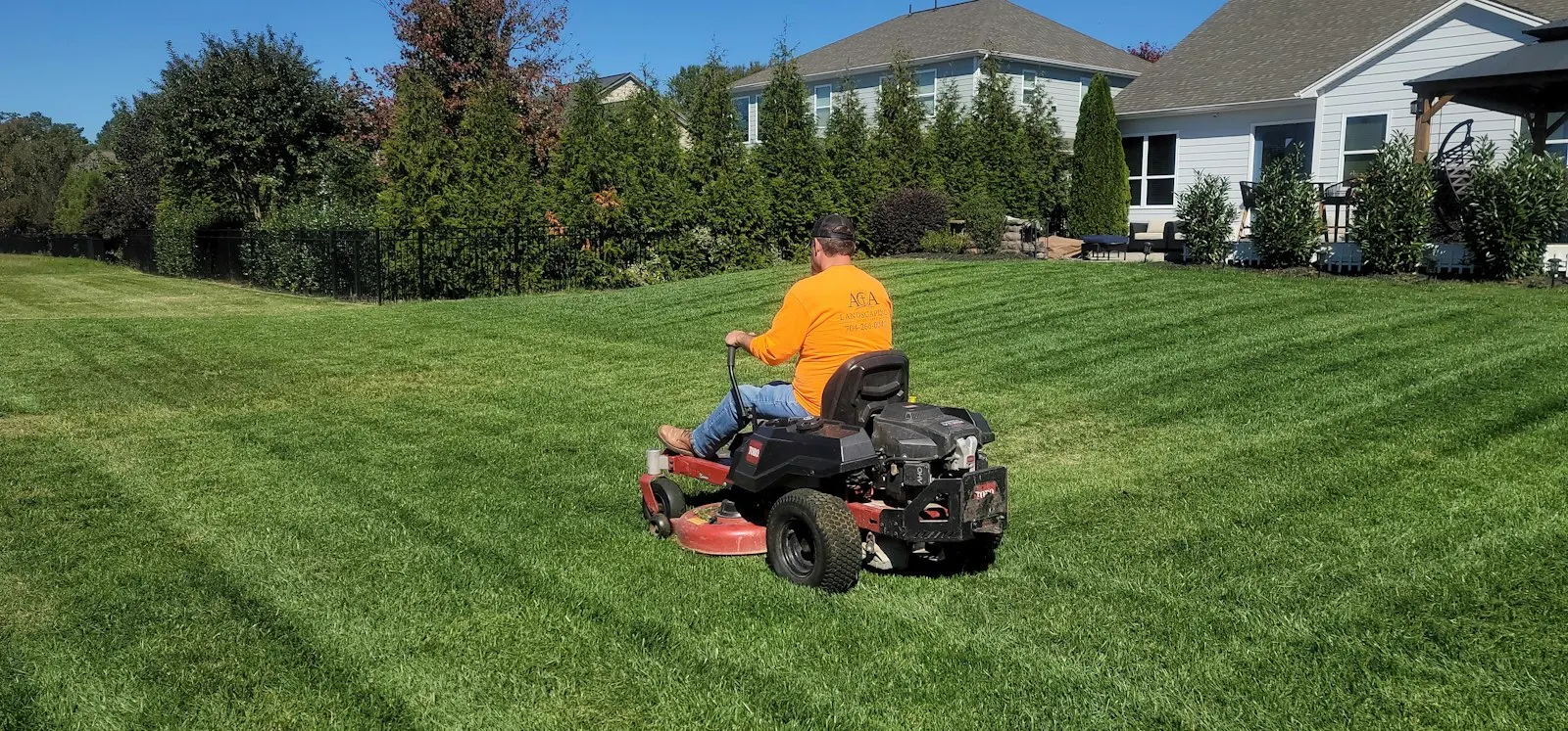 Staples Lawn Care crew and mower at work on a property